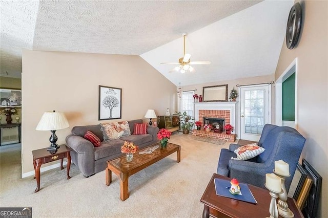 carpeted living room with a fireplace, a textured ceiling, ceiling fan, and lofted ceiling