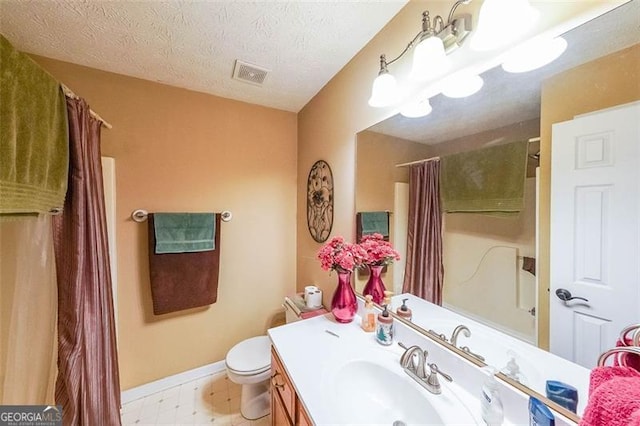 bathroom with vanity, a textured ceiling, toilet, and walk in shower