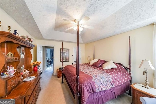 carpeted bedroom with ceiling fan and a textured ceiling