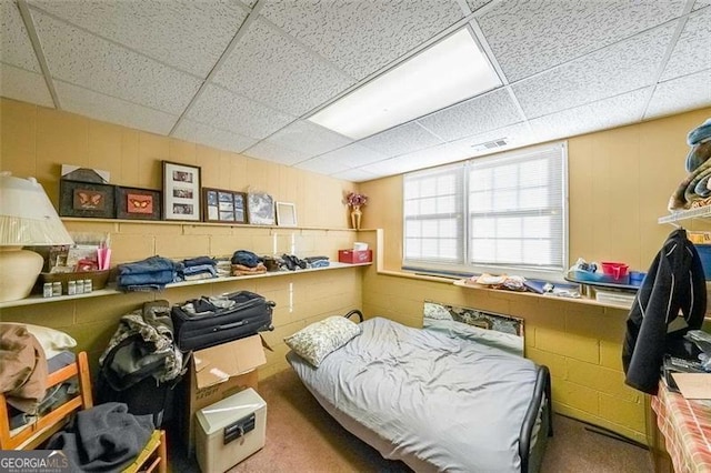 bedroom featuring carpet and a drop ceiling