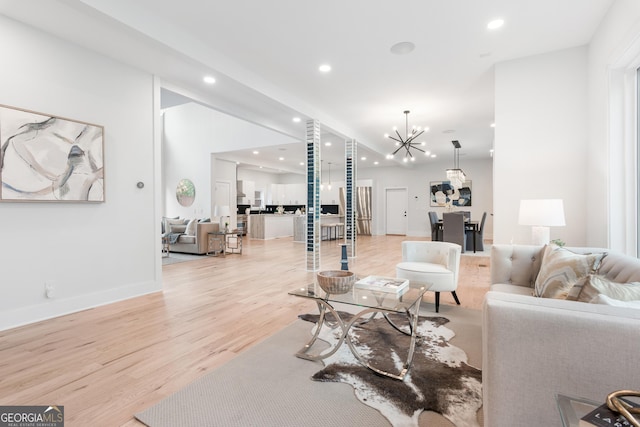 living room with light hardwood / wood-style flooring and a notable chandelier