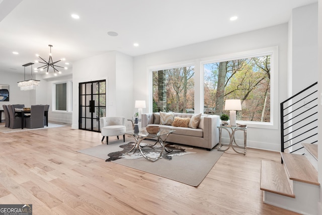 living room featuring light hardwood / wood-style floors and an inviting chandelier