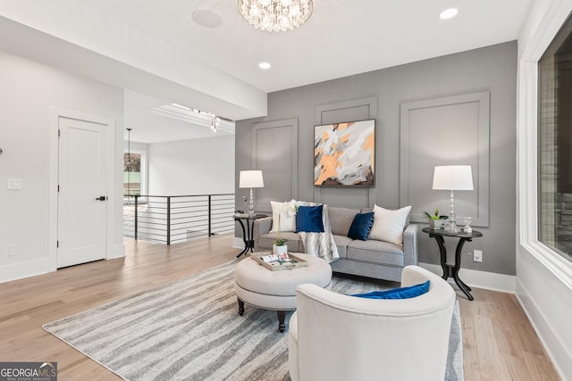 living room featuring light hardwood / wood-style floors and an inviting chandelier