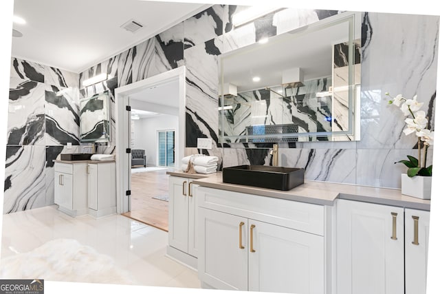 kitchen with white cabinets, tile walls, and a healthy amount of sunlight