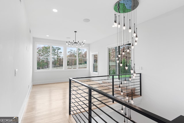 corridor featuring light wood-type flooring and a chandelier