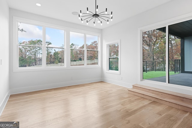 unfurnished sunroom featuring a chandelier and plenty of natural light