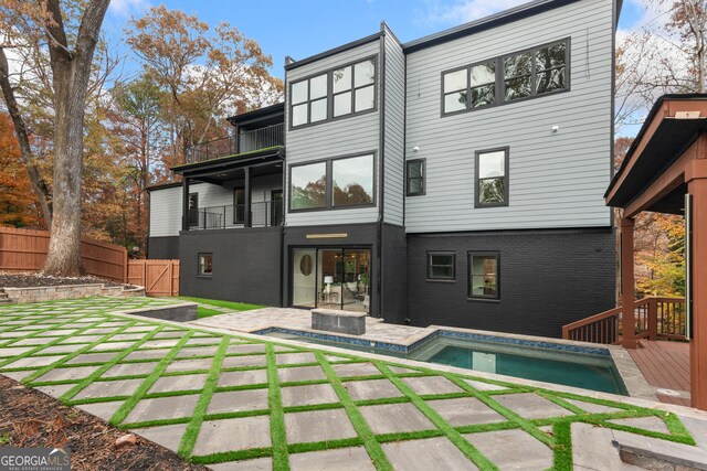 rear view of house with a patio area and a balcony