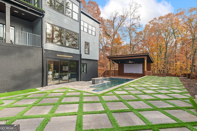 exterior space with a pool with hot tub and a balcony