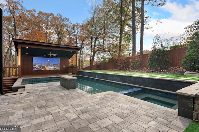 view of swimming pool with ceiling fan and an in ground hot tub