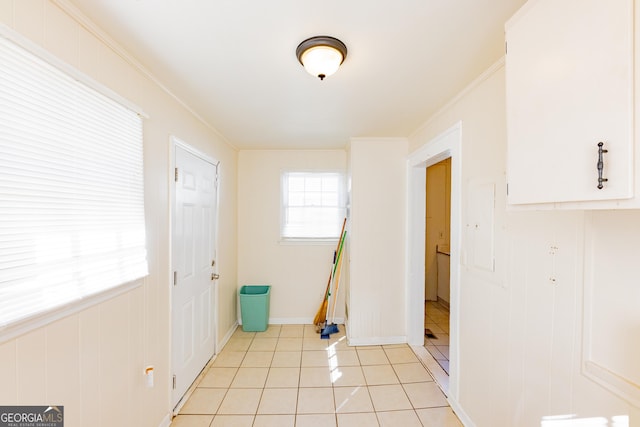 interior space featuring crown molding and light tile patterned flooring