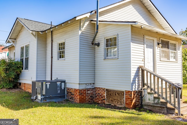 view of side of property featuring a lawn and central AC unit