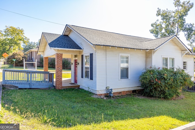 view of front of property with a wooden deck and a front lawn