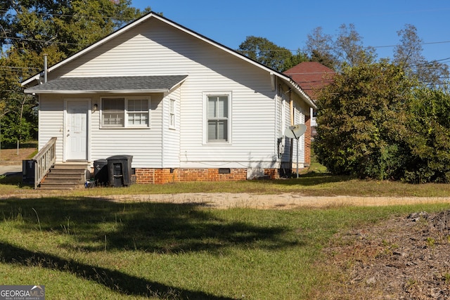 rear view of house featuring a lawn