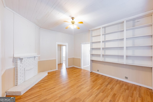 unfurnished living room featuring built in shelves, ceiling fan, a brick fireplace, light hardwood / wood-style flooring, and wood ceiling