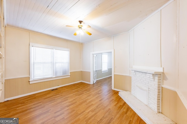 unfurnished living room with a fireplace, light wood-type flooring, ceiling fan, and wood ceiling