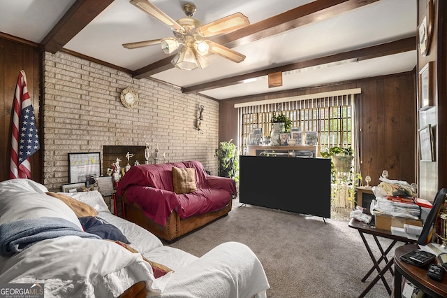 carpeted living room with wooden walls, beamed ceiling, brick wall, and ceiling fan