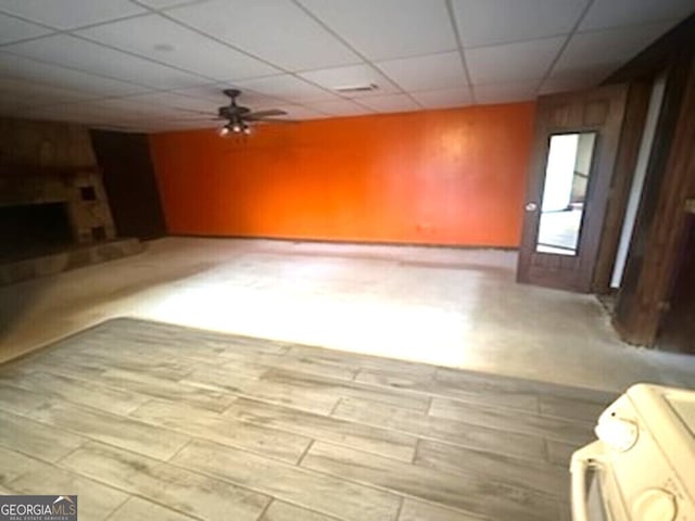 unfurnished living room with a paneled ceiling, light hardwood / wood-style floors, and ceiling fan