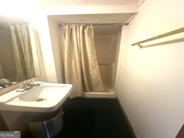 bathroom with a shower with shower curtain and sink