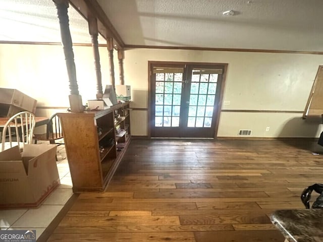 doorway to outside with french doors, dark hardwood / wood-style flooring, and a textured ceiling