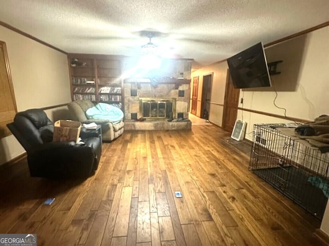 living room with a fireplace, a textured ceiling, and hardwood / wood-style flooring