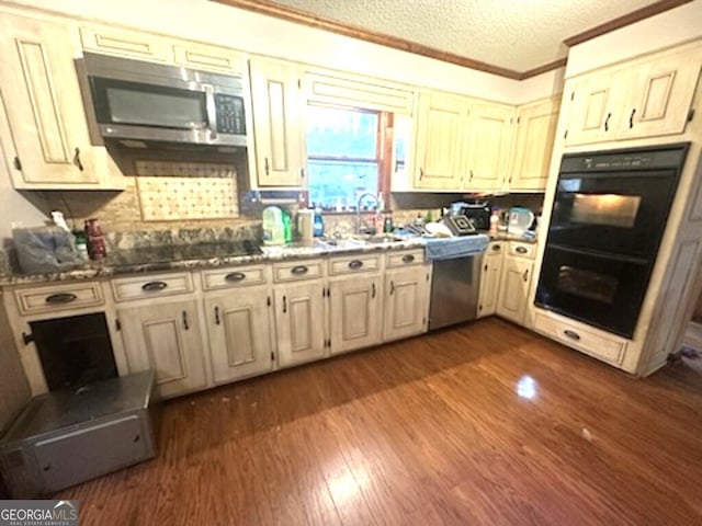 kitchen with dark hardwood / wood-style floors, crown molding, a textured ceiling, decorative backsplash, and appliances with stainless steel finishes