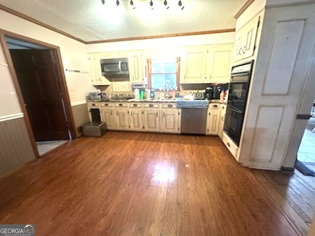 kitchen with dark wood-type flooring, stainless steel appliances, crown molding, a textured ceiling, and decorative backsplash