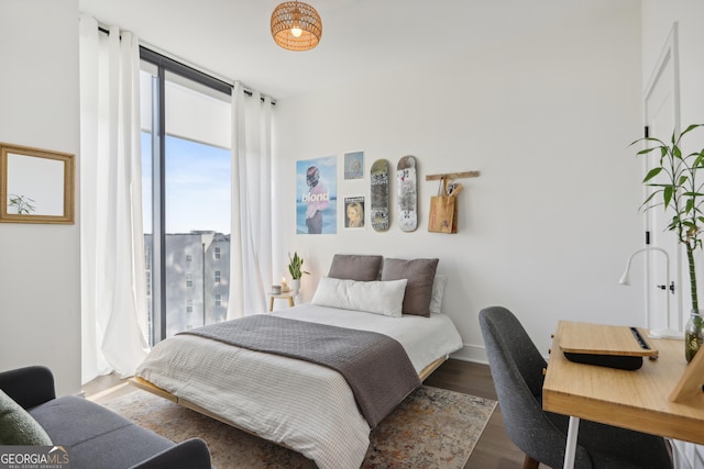 bedroom featuring dark hardwood / wood-style floors and a wall of windows