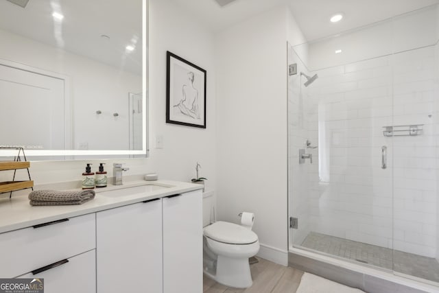 bathroom with vanity, toilet, wood-type flooring, and walk in shower