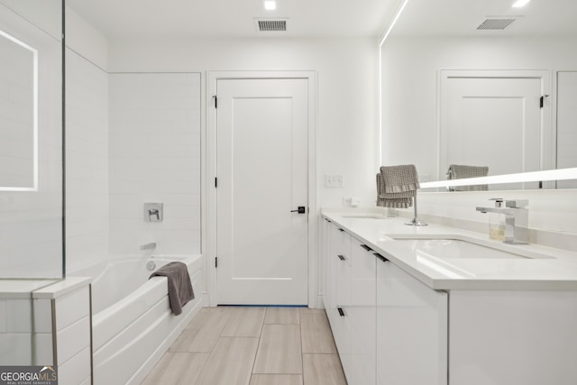 bathroom featuring vanity and tiled shower / bath