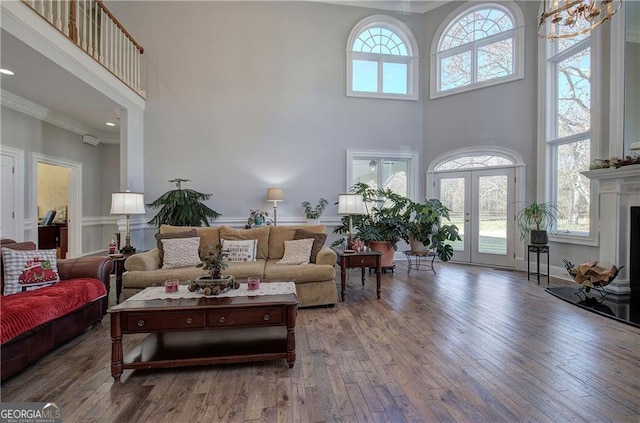 living room with a towering ceiling, a wealth of natural light, and ornamental molding