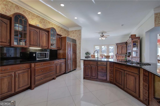 kitchen featuring ceiling fan, sink, crown molding, light tile patterned floors, and appliances with stainless steel finishes