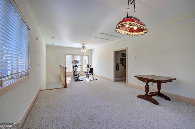 exercise area with ceiling fan, crown molding, and light colored carpet