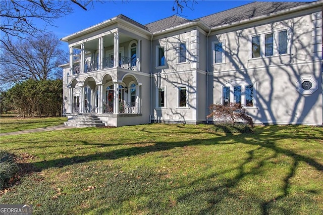 view of front facade featuring a front yard and a balcony