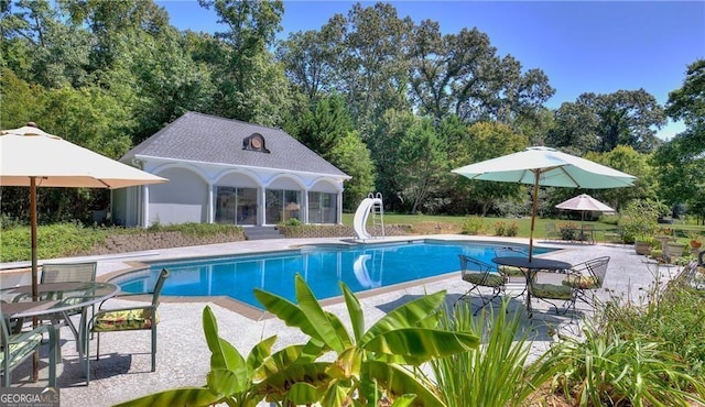 view of pool featuring a patio area and a water slide