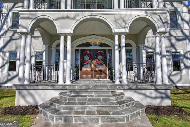 entrance to property featuring a porch and french doors