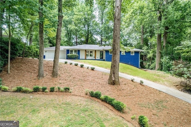 ranch-style house with a garage and a front lawn