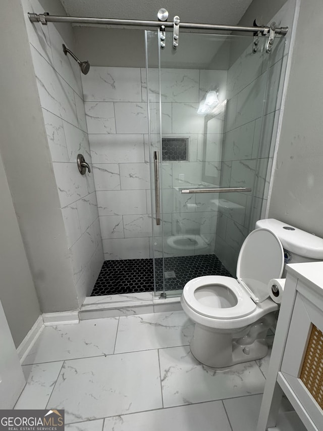 bathroom featuring vanity, toilet, and a shower with door