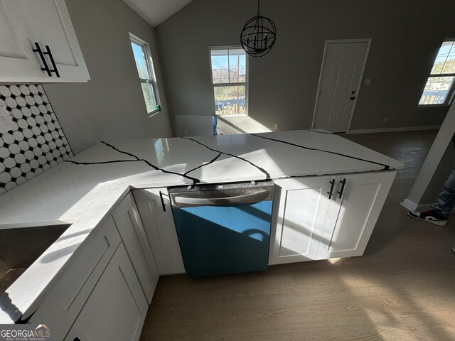 kitchen featuring hardwood / wood-style flooring, plenty of natural light, hanging light fixtures, and black dishwasher