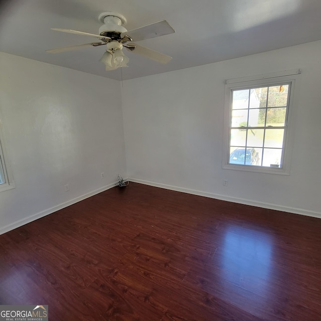 unfurnished room featuring dark wood-type flooring and ceiling fan