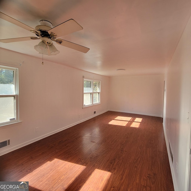 spare room with dark hardwood / wood-style floors and ceiling fan