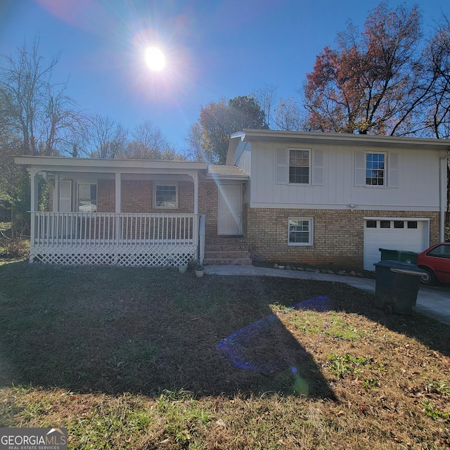 view of front facade with a garage, a porch, and a front lawn