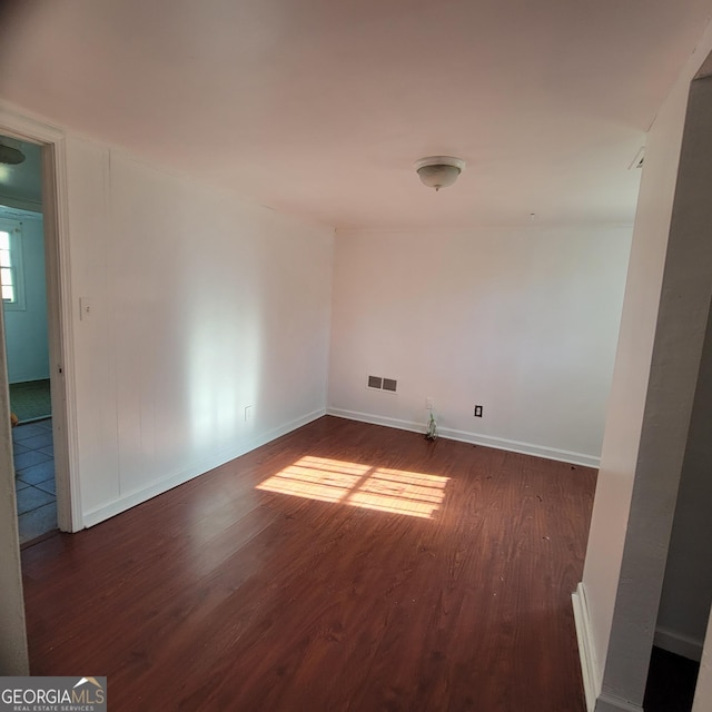 empty room with dark hardwood / wood-style flooring