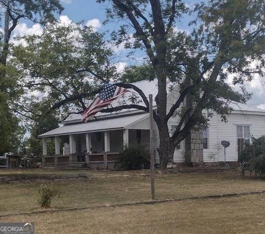 view of front of property with covered porch and a front yard