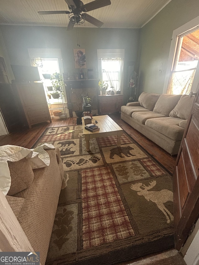 living room with ceiling fan, dark hardwood / wood-style flooring, and wooden ceiling