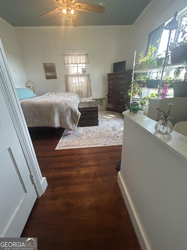 bedroom with ceiling fan and dark hardwood / wood-style flooring