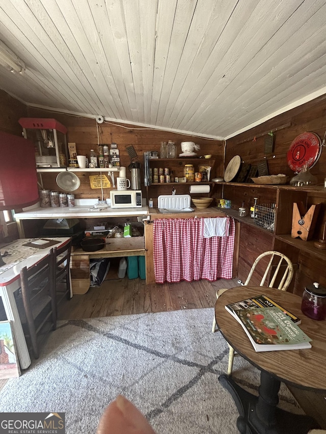 kitchen featuring wood-type flooring, wood ceiling, lofted ceiling, and wood walls