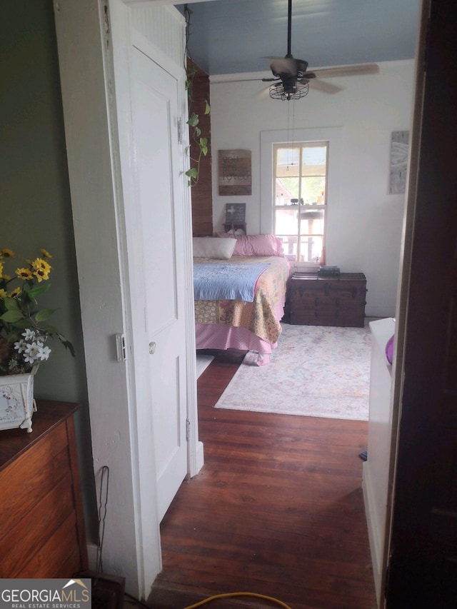 bedroom with dark hardwood / wood-style floors and ceiling fan