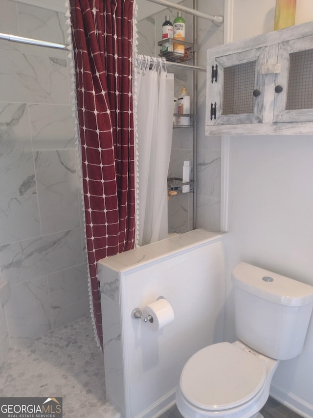 bathroom featuring toilet and walk in shower