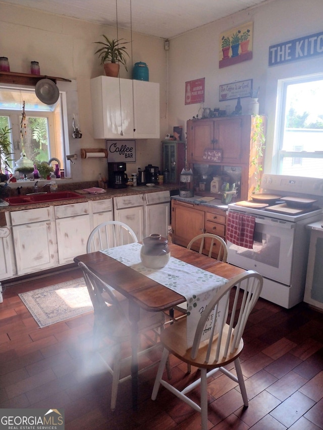 kitchen featuring white range oven, sink, white cabinets, and dark wood-type flooring