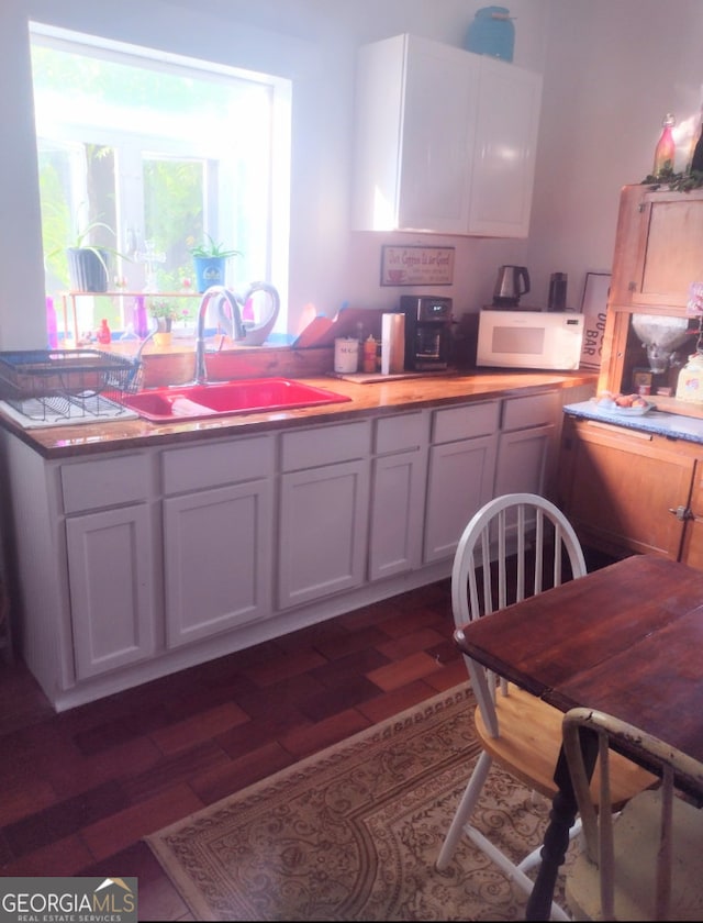 kitchen featuring white cabinetry, sink, and dark hardwood / wood-style floors